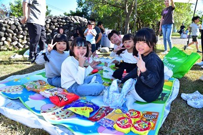小朋友開心地坐在草地上野餐_0